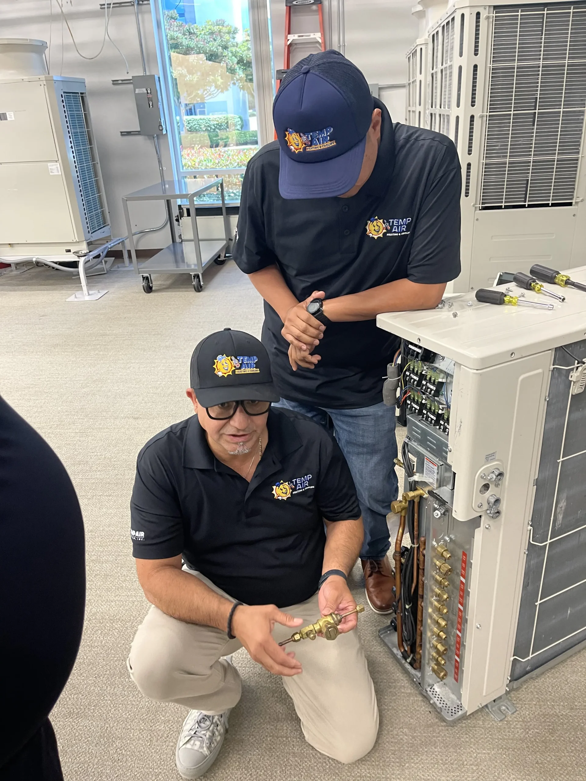 Two technicians working on a HVAC system.